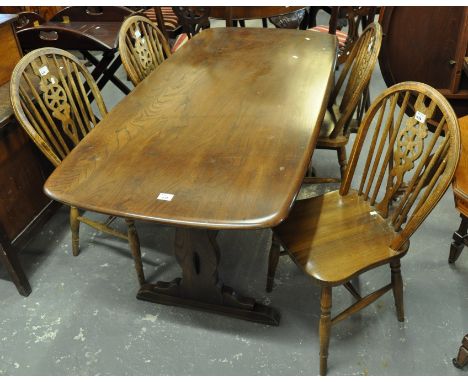 Mid Century elm Ercol refectory type dining table, together with a set of four wheel back kitchen chairs. (5)(B.P. 21% + VAT)