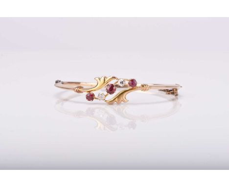 An early 20th century untested ruby and diamond bangle, the three graduated round mixed cut rubies interspersed with two old 