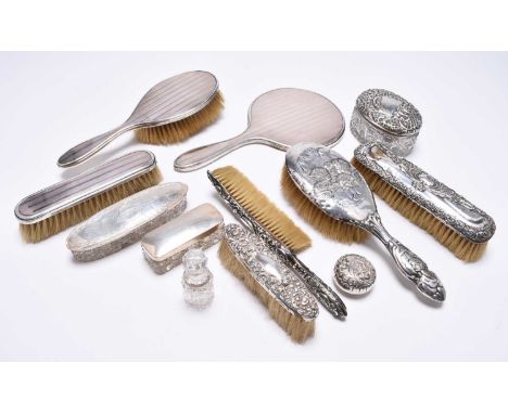 A collection of silver mounted dressing table wares, comprising; a hand mirror with rose metal embellishment with matching cl