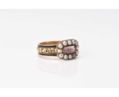 An early 19th century seed pearl and black enamel mourning ring, designed as a central crystal cabochon within a border of tw