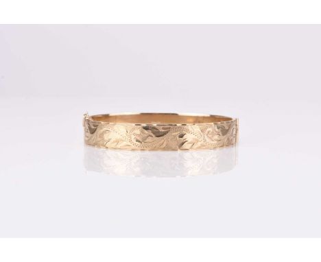 A 9ct gold bright cut engraved hinged bangle, hallmarked Birmingham 1994, weight approx 19.2g