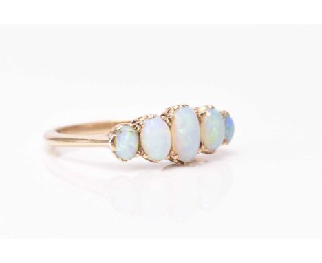 A late 19th century five stone graduated opal ring, the oval cabochon opals claw set in yellow metal, the yellow metal shank 