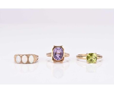 A 9ct gold single stone amethyst ring, size O, together with a 9ct gold single stone peridot ring, size S and a 9ct gold thre