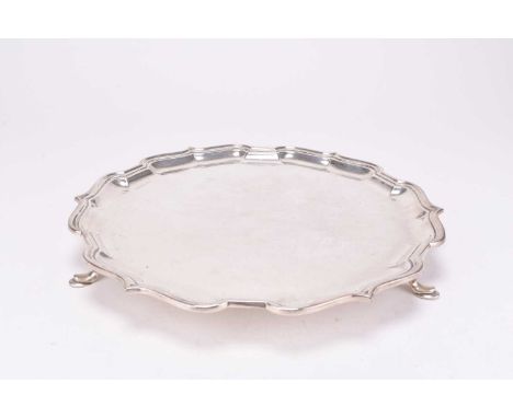 A silver salver, Mappin &amp; Webb, Sheffield 1964, of circular form with pie crust rim, raised on three stepped feet, 27.5cm