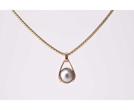 A cultured pearl pendant on chain, the single cultured pearl encased in yellow metal pendant mount, suspended from yellow met