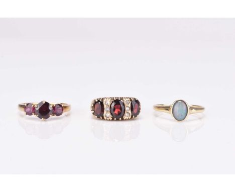 A 9ct gold three stone garnet ring, size N, together with a 9ct gold opal triplet ring, size T, and a further 9ct gold ring, 