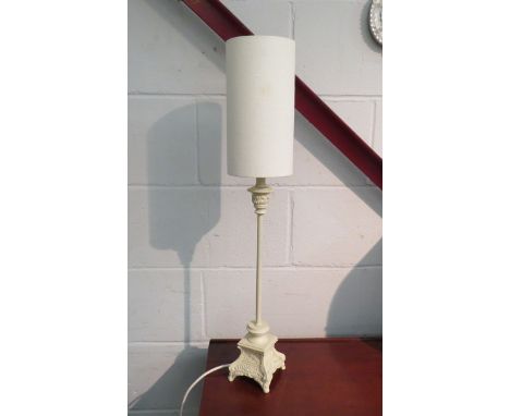 A slender table lamp with cream base and shade 