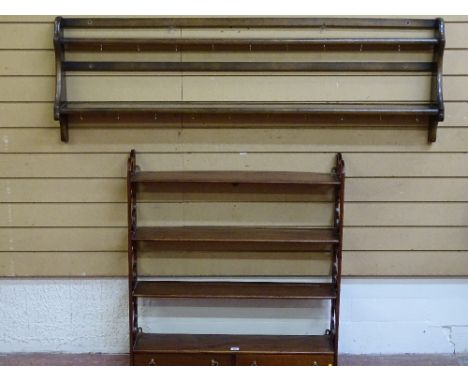 AN ERCOL STYLE WALL RACK and a reproduction mahogany four shelf display rack with twin lower drawers, 144.5 cms and 81.5 cms 