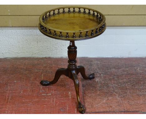 A CIRCULAR TOPPED VICTORIAN STYLE WINE TABLE with baluster gallery top, turned column, on a carved knee tripod base with ball