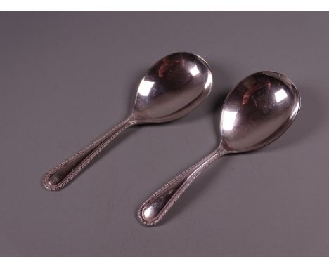 A NEAR PAIR OF SILVER CADDY SPOONS with gadrooned handle edges, 1 troy oz, Birmingham 1976/7 by Hampton Utilities