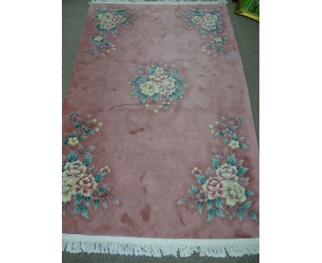 A PINK CHINESE WASHED WOOL CARPET with pastel floral pattern and tasselled ends, 260 x 184 cms approximately