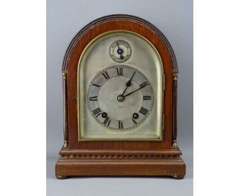 A DOME TOPPED MAHOGANY EDWARDIAN MANTEL CLOCK, the silvered dial set with Roman numerals and slow-fast dial, the movement wit
