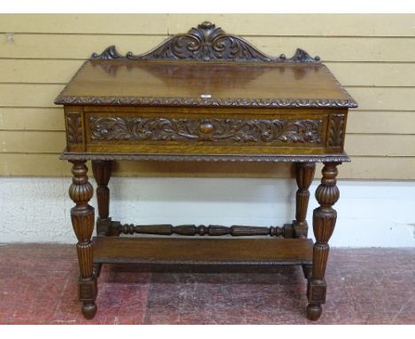 A CARVED OAK SINGLE DRAWER HALL TABLE with rail back and egg and dart moulding, on reeded block and turned supports, with und