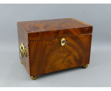 A GEORGIAN MAHOGANY TEA CADDY, rectangular form with ring handles on brass bun feet, with inlaid string edging, 14.5 cms high
