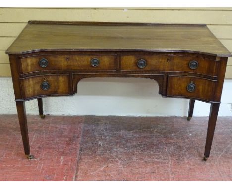 A REPRODUCTION REGENCY STYLE MAHOGANY DESK, the shaped front having an arrangement of four drawers on tapering supports with 