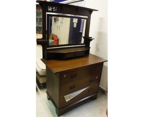 An early 20th Century oak dressingchest in the Arts and Crafts manner, the mirrored super structure above three long drawers 