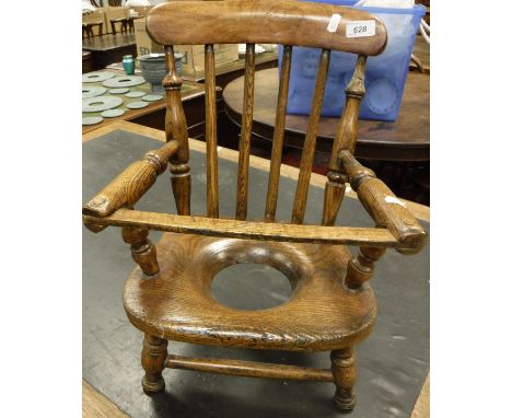 A childs oak and beech stick back kitchen type commode chair