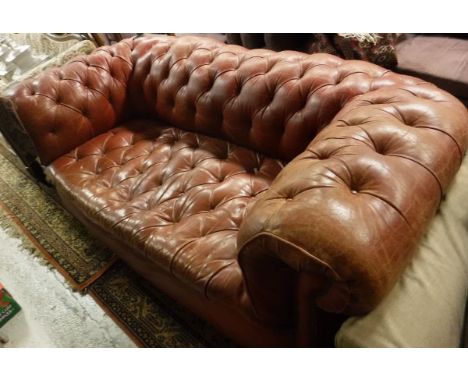 A circa 1900 buttoned red leather upholstered Chesterfield sofa on turned and ringed front legs  to castors CONDITION REPORTS