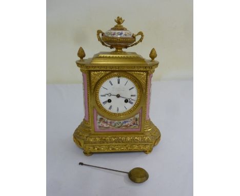 A French 19th century gilt metal mantle clock with Sevres style panels, enamel dial with Roman numerals, two train movement t