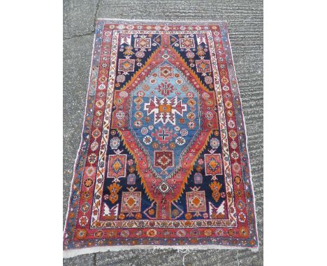 Persian wool carpet, central geometric medallion within light blue border, 194 x 127cm