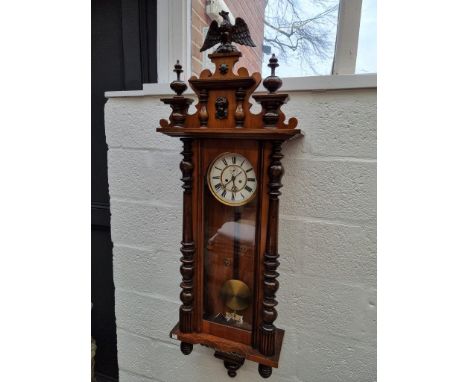 A late 19th century walnut Vienna style wall clock,&nbsp;139cm high, with weights and pendulum.&nbsp; 