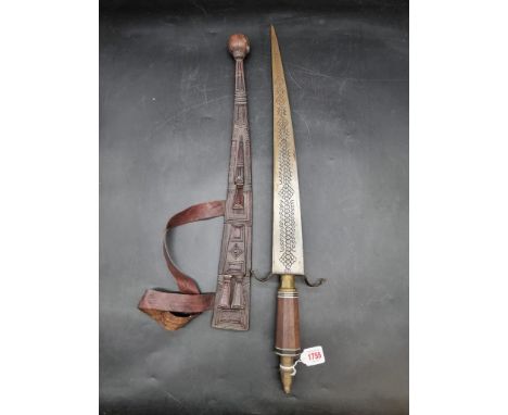 Ethnographica:&nbsp;an African sword and embossed leather scabbard, probably Nigerian, with 55cm blade.&nbsp;