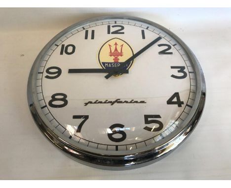A decorative chrome framed circular wall clock with Maserati decals.
