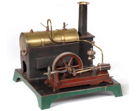 Bassett-Lowke Live Steam Engine with horizontal brass boiler mounted on plain stand with chimney connected to a Doll single f