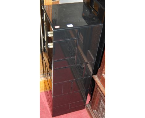 A pair of contemporary black mirrored glass square pedestals, together with a further smoky glass shelf (with damages) (3)