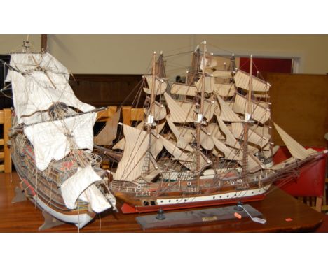 Four various model sailing vessels, each raised on stands