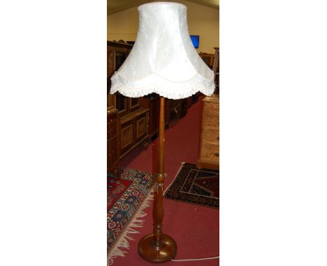 An early 20th century turned mahogany standard lamp, having reeded detail with silk shade, overall height 185cm