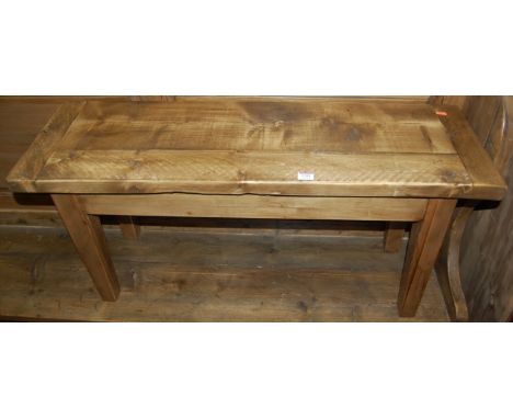 A rustic stained pine two seater bench, having cleated ends and of plain form, length 102cm