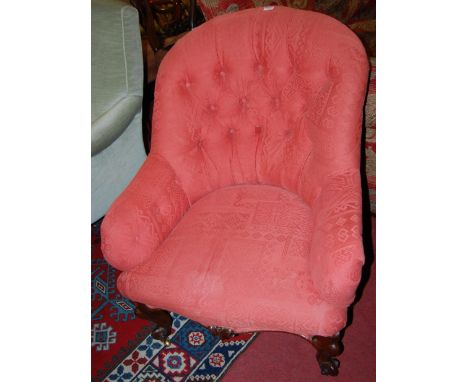 A mid-Victorian mahogany framed and floral button back upholstered tub armchair, raised on squat scroll cabriole forelegs, wi