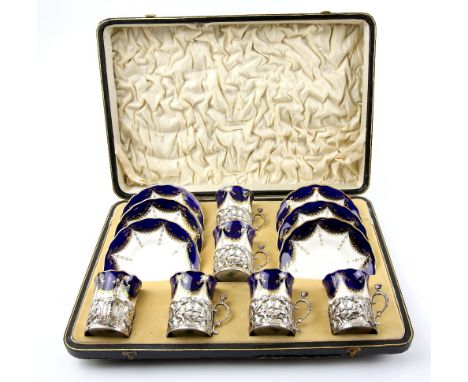 Set of six Coalport porcelain blue, white and gilt coffee cups and saucers, in silver holders with putti and scrolling decora