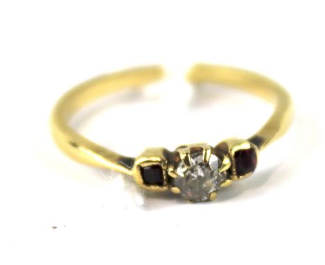 An unmarked yellow metal ladies gem set ring. With century claw set diamond flanked by a single ruby on either side, UK ring 