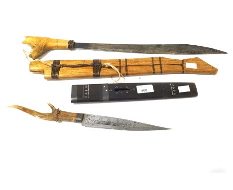 Two swords. Comprising a shaped blade in a wooden scabbard and a smaller engraved blade with horn handle. Length of blades 42