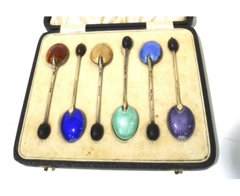 A boxed set of six Edwardian silver and enamel teaspoons. Hallmarked Birmingham 1909, all with enamel work decoration to the 