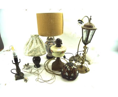 A group of table lamps. Including a Tiffany style leaded shade, a Victorian gas lamp with painted reservoir, and further exam