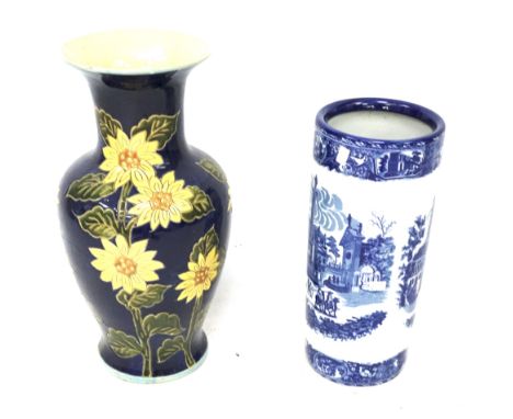 A large ceramic vase and a blue and white umbrella stand. The first decorated with sunflowers, heights 54cm and 44cm.