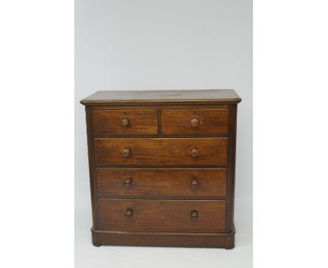 A Victorian mahogany chest of drawers. Two short over three long drawers, all with turned handles, raised on plinth base with