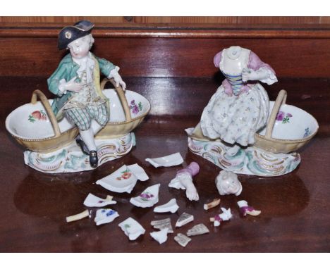 A Meissen figural sweetmeat stand, of a young gallant, in fancy dress seated on two baskets, scroll base, 14cm crossed swords