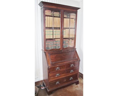 An Art Nouveau mahogany bureau bookcase, outswept cornice above a pair of glazed doors, fall front enclosing a fitted interio