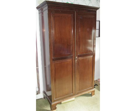 An Edwardian mahogany double wardrobe, dentil cornice above a pair of raised and fielded panelled doors enclosing hanging spa