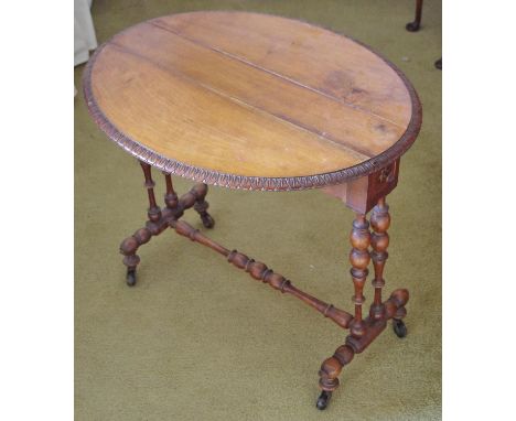 A 19th century walnut Sutherland table, oval top carved with a border of lotus, drawer to end, bobbin-turned underframe, cera