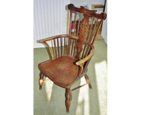 A 19th century elm and ash Windsor elbow chair, shaped cresting rail above a wheel-back splat centred by a draughtsman's-turn