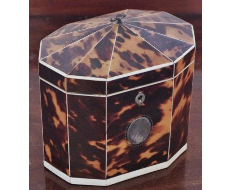 A George III tortoiseshell hexagonal single compartment tea caddy, pointed domed cover, silver axe-head handle, each panel ou