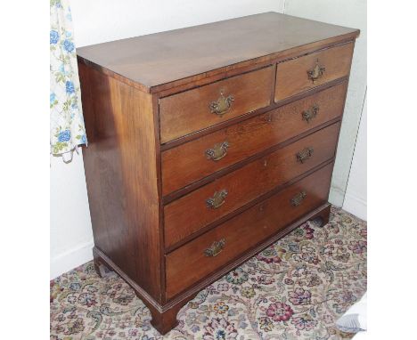 A George III mahogany crossbanded oak chest, oversailing top above two short and three long graduated drawers, brass bat shap