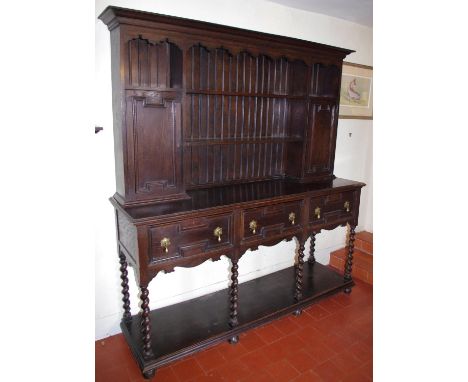 An early 20th century oak dresser, moulded cornice, above open shelves and two enclosed cupboards, the base with block fronte