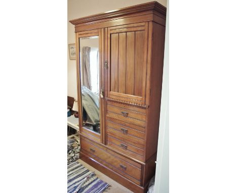 A late Victorian walnut wardrobe, by Maple & Co, London, moulded cornice above a mirrored door flanked by a panelled door enc