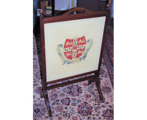 An early 20th century oak rectangular fire screen, turned finials, the tapestry banner with Cambridge University crest, 95cm 